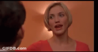 A Woman In A Red Shirt Is Standing Next To A Man In A Room . GIF