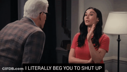 A Woman In A Red Shirt Is Talking To An Older Man In A Suit GIF