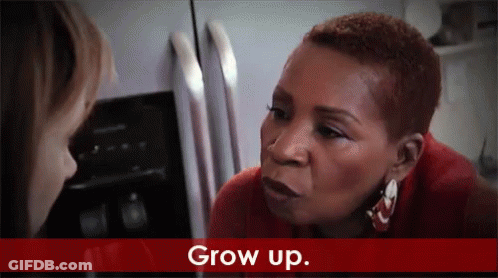 A Woman In A Red Shirt Is Talking To Another Woman In Front Of A Refrigerator And The Words Grow Up Are On The Bottom GIF