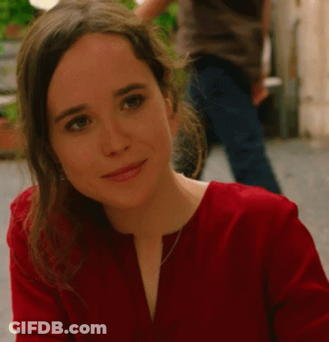 A Woman In A Red Shirt Looks At The Camera GIF
