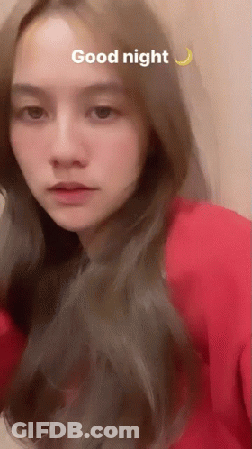 A Woman In A Red Shirt Says Good Night With A Crescent Moon Behind Her GIF