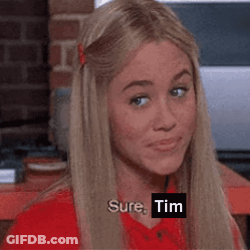 A Woman In A Red Shirt Says " Sure Tim " While Looking At The Camera GIF