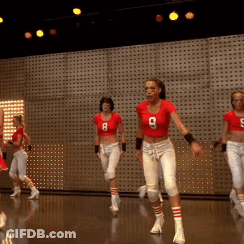 A Woman In A Red Shirt With The Number 8 On It Is Dancing GIF