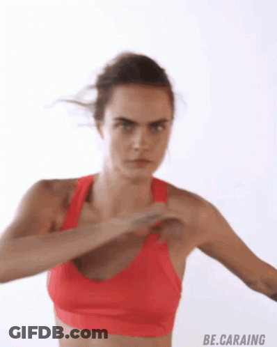 A Woman In A Red Sports Bra Is Doing A Fist Pump GIF