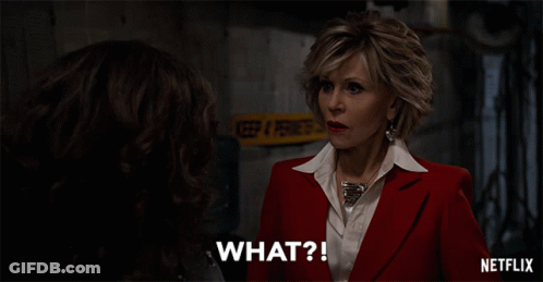 A Woman In A Red Suit And White Shirt Says What GIF