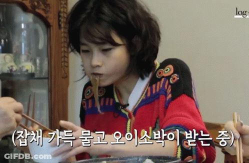 A Woman In A Red Sweater Is Eating Noodles With Chopsticks In A Video That Says Log GIF