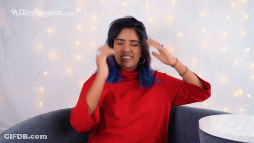 A Woman In A Red Sweater Is Sitting In Front Of A Sign That Says Platform Indonesia.com GIF