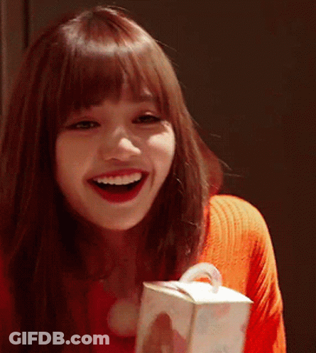 A Woman In A Red Sweater Is Smiling While Holding A Box GIF