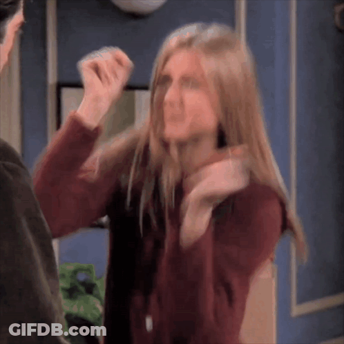 A Woman In A Red Sweater Is Standing Next To A Man And Making A Funny Face . GIF