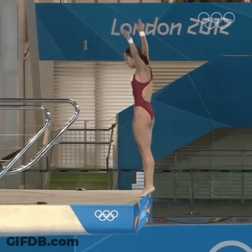 A Woman In A Red Swimsuit Is Jumping Off A Diving Board In Front Of A London 2012 Sign GIF