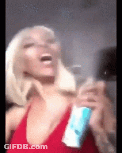 A Woman In A Red Tank Top Is Laughing And Holding A Can Of Soda . GIF