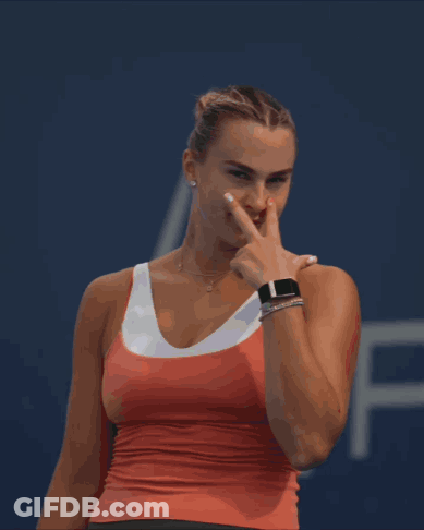 A Woman In A Red Tank Top Is Pointing At Something GIF