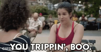 A Woman In A Red Tank Top Is Sitting At A Table With Another Woman . GIF