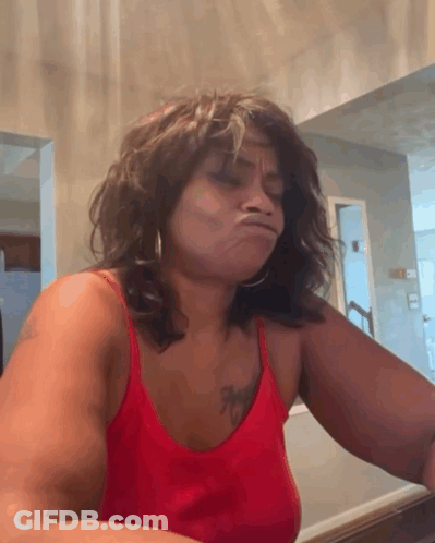 A Woman In A Red Tank Top With A Tattoo On Her Chest GIF