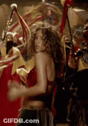 A Woman In A Red Top Is Dancing In A Crowd Of People GIF