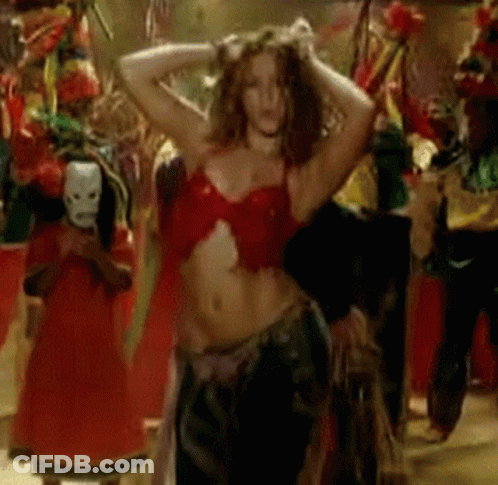 A Woman In A Red Top Is Dancing In A Crowd Of People GIF