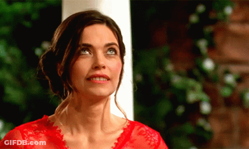 A Woman In A Red Top Is Looking Up At Something GIF