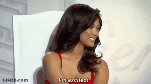 A Woman In A Red Top Is Sitting In A Chair And Says I 'M Excited GIF