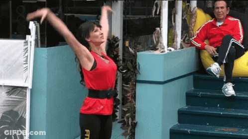 A Woman In A Red Top With The Word Fit On Her Leggings GIF