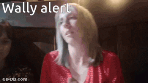 A Woman In A Red Top With The Words Wally Alert Below Her GIF