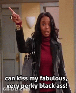 A Woman In A Red Turtleneck And Black Jacket Is Pointing At The Camera And Saying Can Kiss My Fabulous Very Perky Black GIF