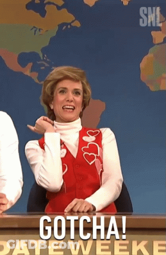 A Woman In A Red Vest Is Sitting At A Desk With The Words Gotcha On It GIF