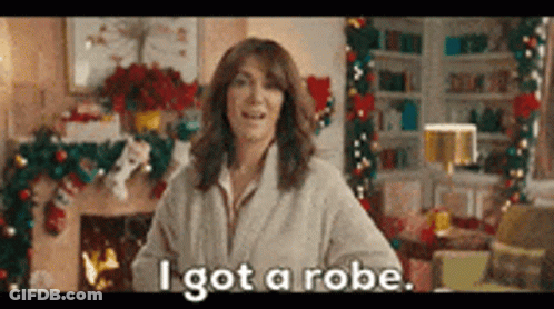 Woman In Robe Standing By Fireplace GIF
