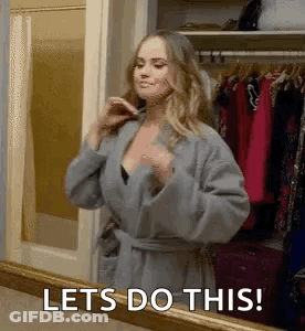 A Woman In A Robe Is Standing In Front Of A Mirror And Saying `` Lets Do This ! '' GIF