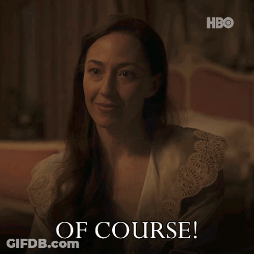 A Woman In A Robe Says " Of Course " In A Dark Room GIF