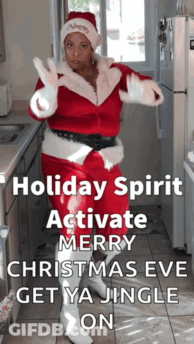 A Woman In A Santa Costume Is Dancing In A Kitchen With The Words Holiday Spirit Activate Merry Christmas Eve Get Ya Jin GIF
