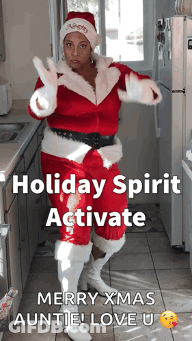 A Woman In A Santa Suit Is Dancing In A Kitchen GIF