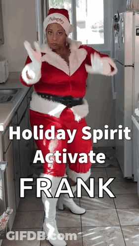 A Woman In A Santa Suit Is Standing In A Kitchen GIF