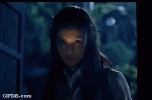 A Woman In A School Uniform And Tie Is Standing In Front Of A Door . GIF