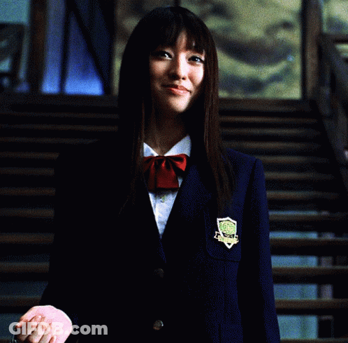 A Woman In A School Uniform Holding A Chain Around Her Neck GIF
