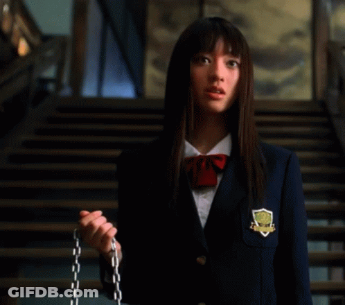 A Woman In A School Uniform Is Standing In Front Of Stairs . GIF