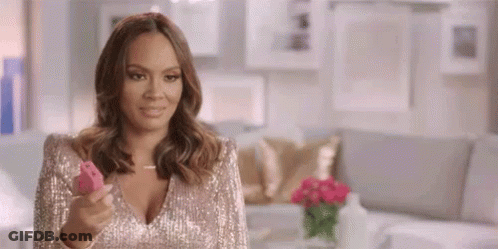 A Woman In A Sequined Dress Is Holding A Pink Object . GIF