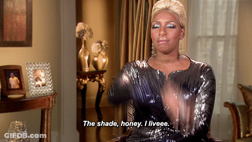A Woman In A Sequined Dress Is Sitting In A Chair And Says The Shade Honey I Liveee GIF
