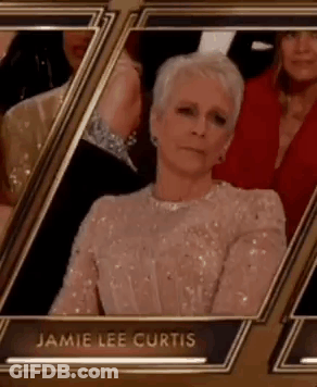 A Woman In A Sequined Dress Is Sitting In A Row Of Frames At An Event . GIF