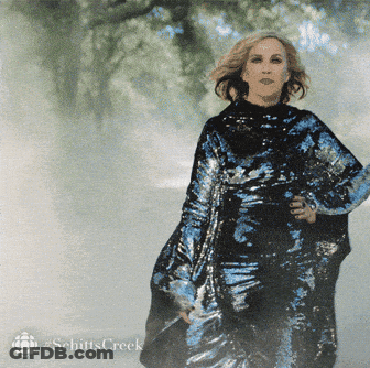 A Woman In A Sequined Dress With The Word Schitts Creek On The Bottom Left GIF