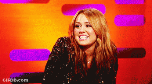 A Woman In A Sequined Jacket Smiles In Front Of A Purple And Orange Background GIF