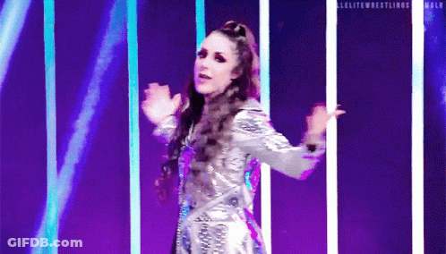 A Woman In A Silver Dress Is Dancing On A Stage In Front Of Purple Lights . GIF