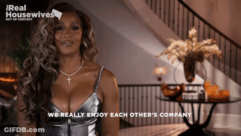 A Woman In A Silver Dress With The Words We Really Enjoy Each Other 'S Company Below Her GIF