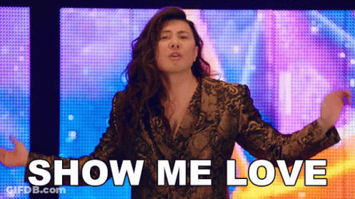 A Woman In A Snake Print Jacket Says Show Me Love In Front Of A Colorful Background GIF