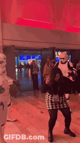 A Woman In A Storm Trooper Costume Is Dancing GIF