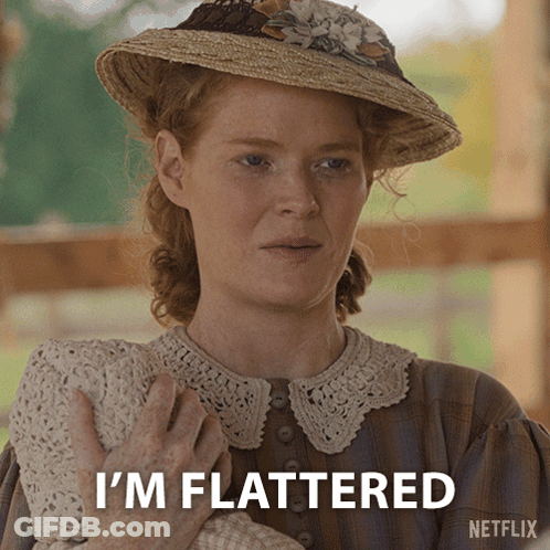 A Woman In A Straw Hat Holds A Baby And Says " I 'M Flattered " GIF