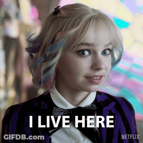 A Woman In A Striped Jacket And Bow Tie Says I Live Here GIF
