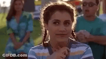 A Woman In A Striped Shirt Is Making A Funny Face . GIF