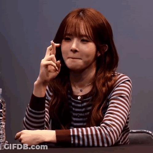 A Woman In A Striped Shirt Is Making A Funny Face GIF