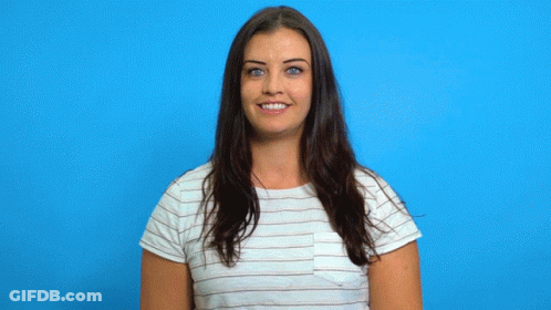 A Woman In A Striped Shirt Is Smiling While Holding A Cardboard Trophy GIF