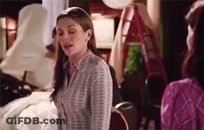 A Woman In A Striped Shirt Is Standing Next To Another Woman In A Pink Shirt . GIF
